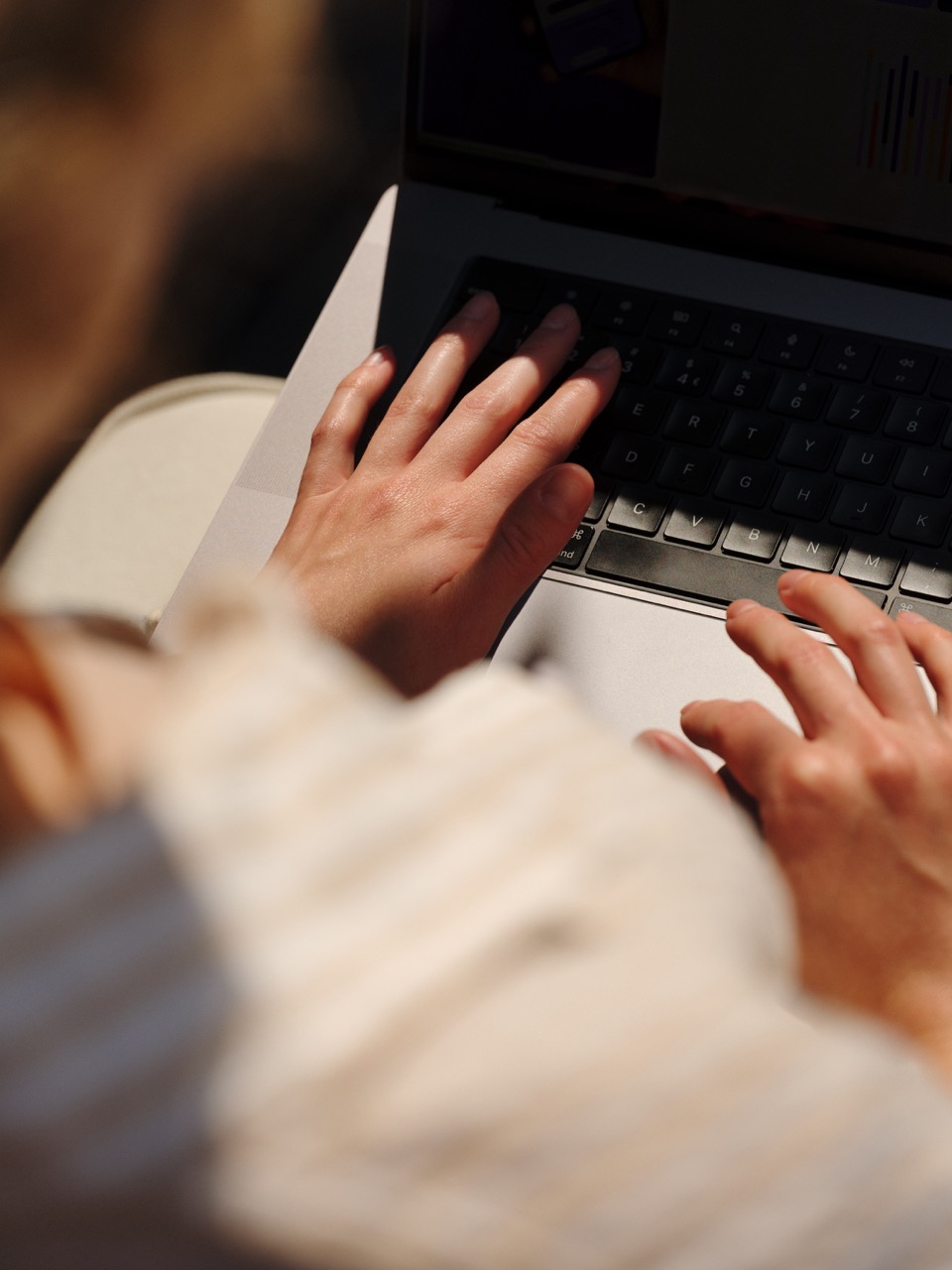 Hands resting on a laptop keyboard